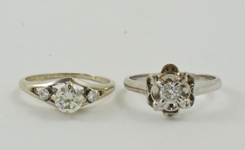 Two Ladies White gold Diamond Solitaire Rings: One engagement ring, 18K with a .25 CT center stone, size 6.5 excellent condition. The other 14K with a .5 CT center stone and two side diamonds, size 6.5 with engraving on the inside of the band, oth