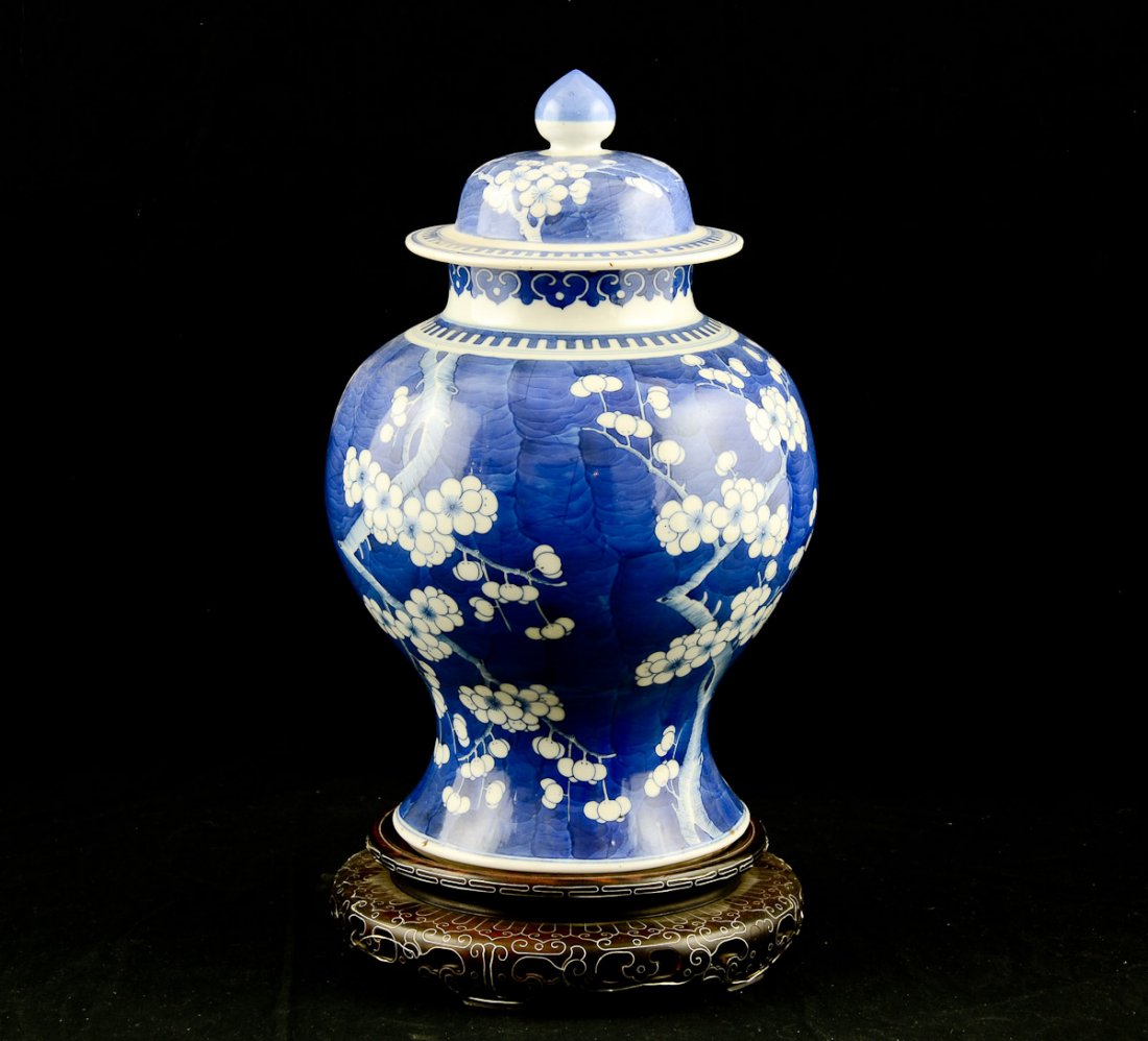 Chinese Blue and White Porcelain Jar: 19th Century, all-over decorated underglaze blue prunus blossoms with double blue circle mark to base. Crisp and vivid painting. High quality. on an inlaid silver wire carved wood base. Very minor rim