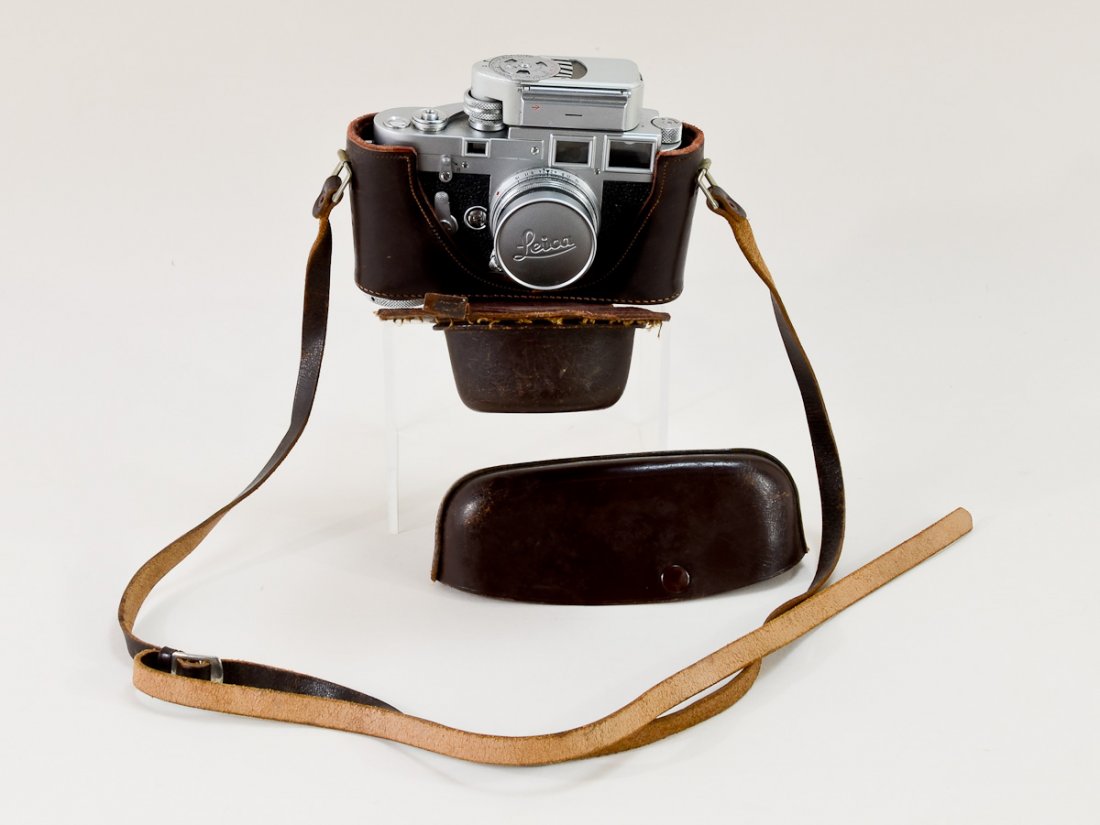 Leica M3 Film Camera: Circa 1957 - 1960 Comes with an attached light meter, a screw mount and a leather case. Clean Condition, appears complete, not tested. Weighs 3 lbs. Written on Top M3-749 956