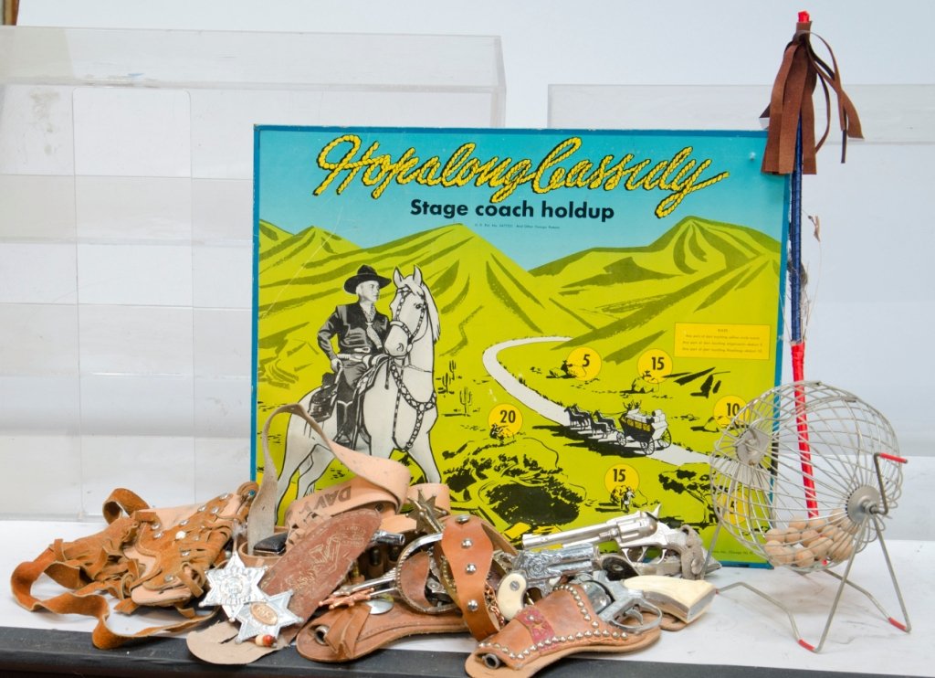 Lot of 3 Assorted Game Items: Lot of 3 Assorted Game Items: 1- Box of assorted western toys including toy guns, bullet belts, spurs, holsters, roll caps, riding crop, play money, and sheriff shields, 1- Hop-A-Long Cassidy tin doub