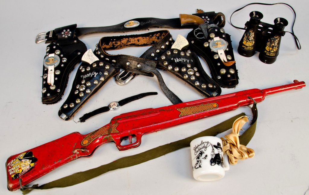 Lot of Misc. Hop-A-Long Cassidy Items: Lot of Misc. Hop-A-Long Cassidy Items: 2 - Leather Child's Holster Belt Sets w/ 3 Cap Guns c1950s, 1 - Hop-A-Long Cassidy Leather Watch, 1 - Pair of Binoculars w/ strap, 1 - Small Mug w/ Hop-A-Long Ca