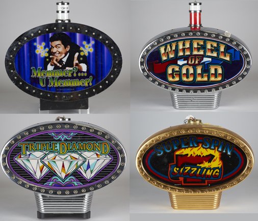 Lot of 4 Oval Light-Up Slot Machine Topper Signs:: Lot of 4 Oval Light-Up Slot Machine Topper Signs: 1 - Sizzling 7 Super Spin, 1 - Triple Diamond, 1 - Wheel of Gold w/ change light & 1 - "Memmer?...U Memmer!" George Lopez w/ change light, All approx.