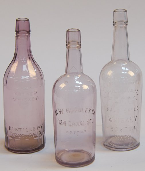 Lot of 3 Embossed Violet-Tint Glass Backbar Bottles:: Lot of 3 Embossed Violet-Tint Glass Backbar Liquor Quart Bottles: 1 - H.W. Huguley Co. 134 Canal St. Boston, 1 - Hayner Whiskey Distillery, Troy, Ohio & 1 - Registered Full Quart Petts' Bald Eagle Whi