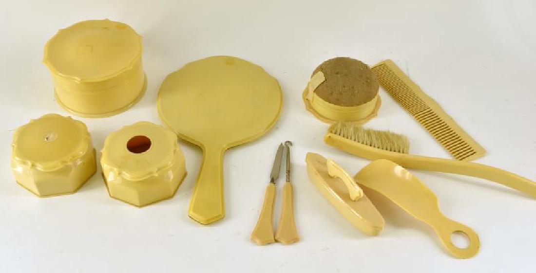 Collection Of Celluloid Dresser Items: Consisting Of Mirror, Brush, Comb, Pin Cushion Hair Receiver, Powder Box, Has Large Chip On Lid, One Jewelry Box, And A Nail Polisher. Eleven Pieces In All