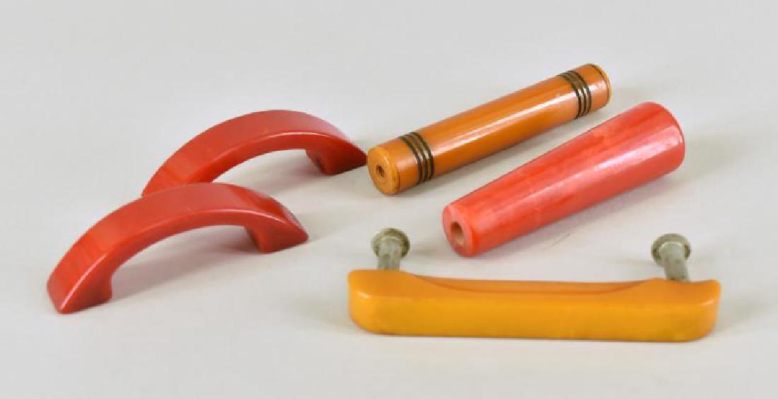 Group Of Bakelite Drawer Pulls: Consisting Of Two Red Arched Handles, A Butterscotch Straight Handle, A Butterscotch Black Ribbed Handle And A Red Cylinder. All Tested Bakelite.
