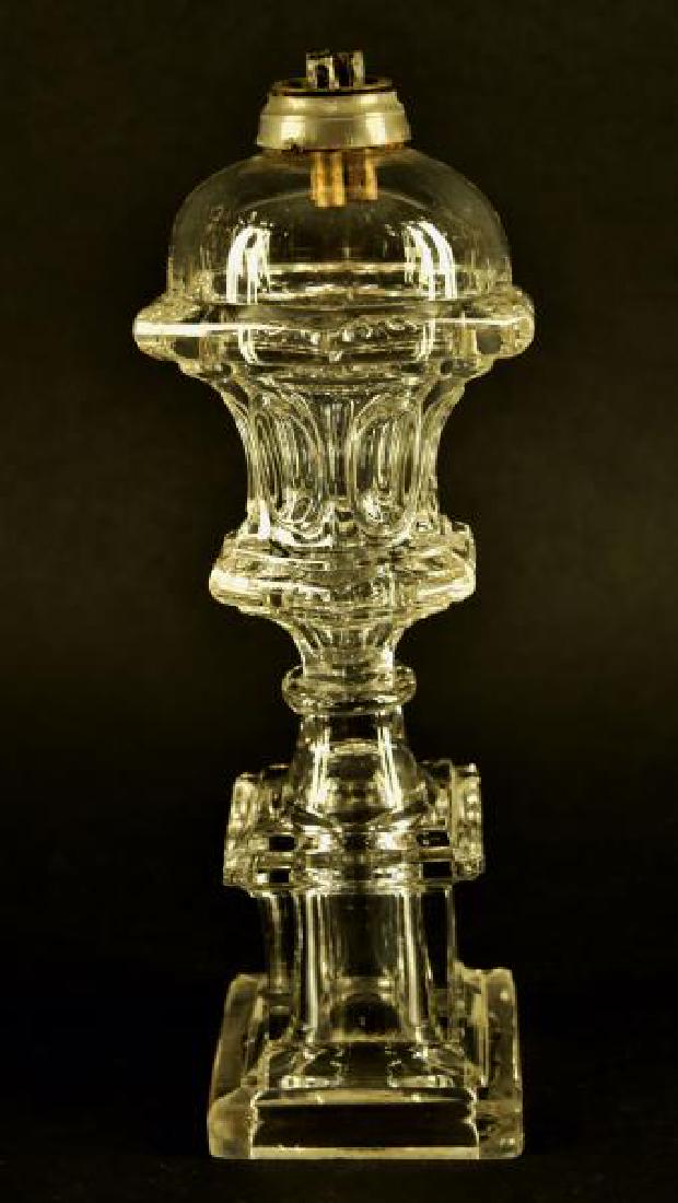 Clear Pressed Whale Oil / Fluid Stand Lamp: Comprising A colorless Wasted Loop Font Raised On A Monument Base, Boston & Sandwich Glass Co. And Others. 1845-1870. Wasted: 11 1/2" H, 3 1/2" Sq Base. Good Condition, No Nicks Chips Or Cracks. Bubbl