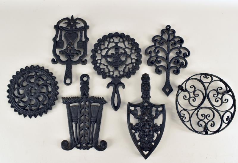 Cast Iron Trivets: Consisting Of Seven Various Cast Iron Trivets By Iron Art And Welton. The All Measure Approximately 9" Long And Between 5" To 6" Wide. All Are In Good Condition Except The Large Round Needs Cleaned.