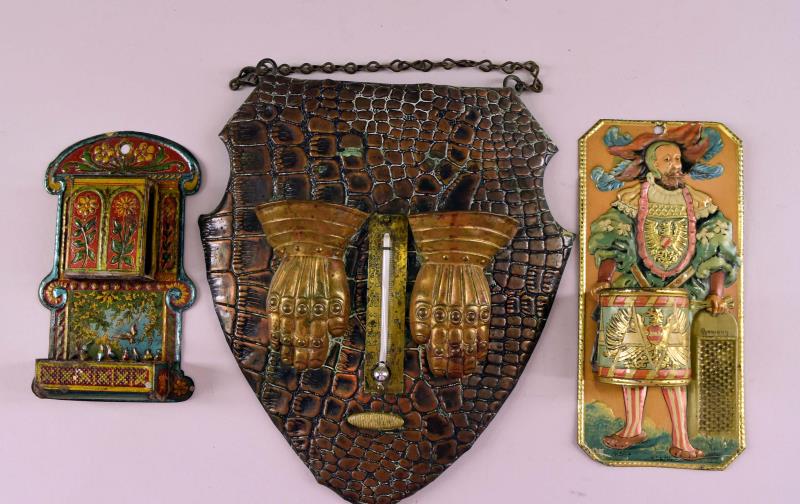 Tin Brass And Copper Match Holders And Strikers: Featuring Two Tin Match Holders And Strikers. Together With A Copper And Brass Match Holder And Striker With Thermometer. The Standing Man Match Holder Is Marked Germany, The Other Us Unmarked. The Co