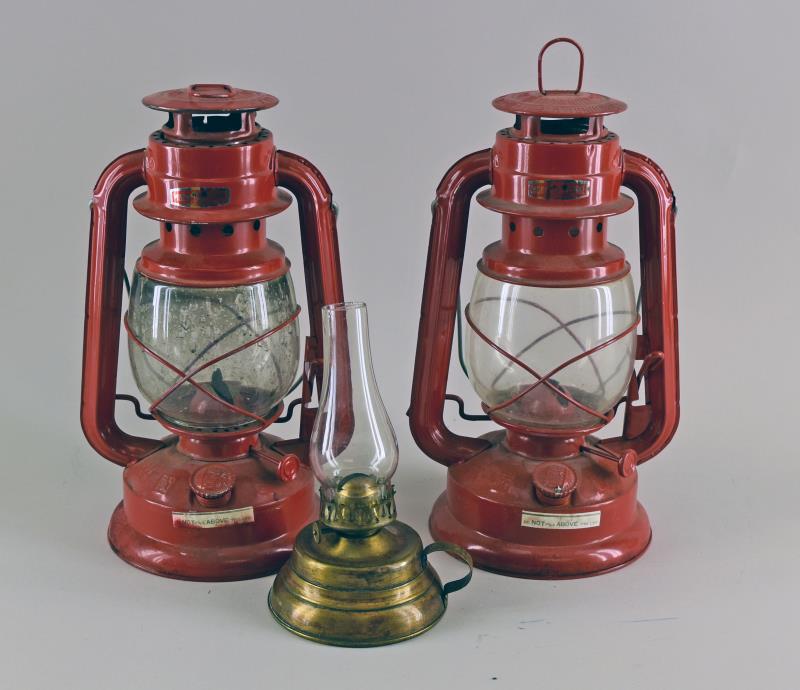 Pair Of Red Barn Lanterns: Both Lamps Are Marked China Guangzhou Moon Light. Both Measure 12" Tall And 6" Wide, In Excellent Condition, One Has Never Been Used. Together With A Small Brass Finger Lamp.