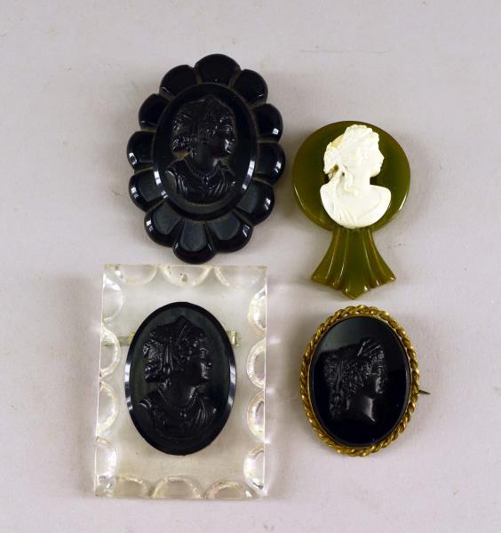 Bakelite And Acrylic Portrait Mourning Pins: Consisting Of Two Bakelite And Acrylic Mourning Pins, A Green Portrait Dress Clip And A Black Glass Mourning Pin. Largest: 3" Long And 2" Wide.