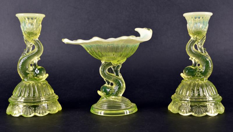 Vaseline Opalescent Dolphin Base Compote: Featuring The Dolphin Base Compote In Opalescent Vaseline Glass, Measuring 5" Tall And 6" Across. In Excellent Condition. Together With A Pair Of Dolphin Base Candlestick In Opalescent Vaseline Glass.