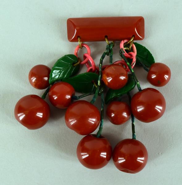 Red Cherry Bakelite Pin: A Bakelite Pin Featuring Hanging Cherries With Leaves, There Are 10 Hanging Cherries, Small And Large, Measuring 4" Long With The 2" Top Pin. The Cherries And Leaves Are In Good Condition, The Chain C