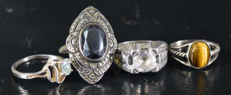 Three Sterling Silver Rings: Featuring A Blue Topaz, Tiger Eye And Rhinestone Rings, All Marked Sterling. Sizes Are 8 On The Topaz Ring, 7.75 On The Rhinestone And 7 On The Tiger Eye. Together With A Misshapen Marcasite & Hematit