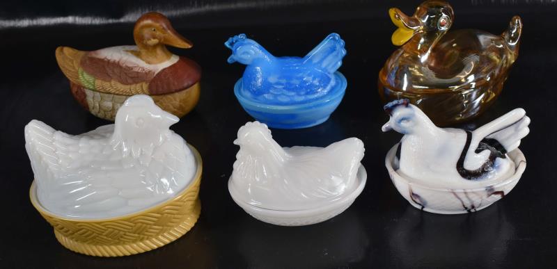 Six Hens And Ducks On A Nest Figures: Featuring A Heisey White And Purple Slag Glass Hen On A Nest, An Avon, Anchor Hocking And An Unmarked Hens On Nests. Together With A Ceramic Duck On A Nest And A Jeanette Glass Duck On A Nest. All Mea