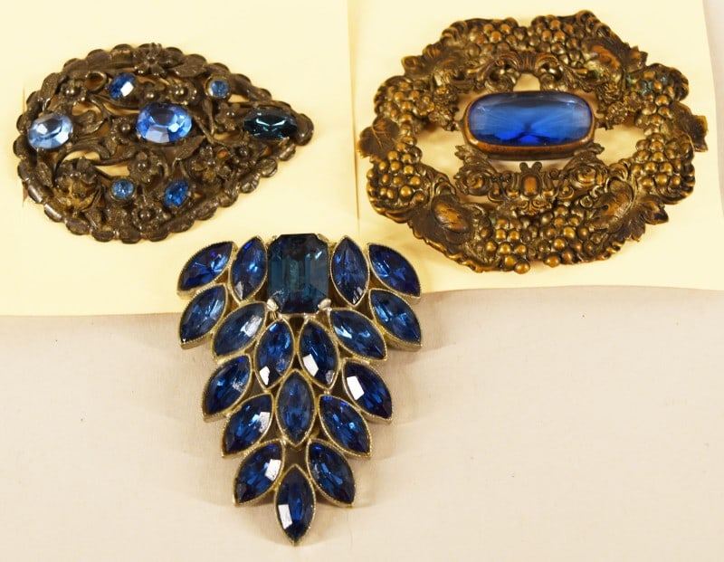 Three Blue Rhinestone Dress Clip And Pins: Featuring A Vintage Czech Filigree Brooch Depicting Wreath Of Grapes And Grape Vine. A Blue Art Deco Rhinestone Floral Filigree Dress Clip And A Leaf Shaped Blue Rhinestone Dress Clip. Measuring Appro