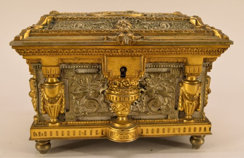 19th Century Ormolu French Gilt Jewelry Casket: Featuring A Square Sarcophagus Form High Relief Gilt Bronze Jewelry Casket. Decorated With Nymph & Cherub Decorations Among Leaf Scrolls. Measuring 4" Tall, 6 1/2" Long And 4 1/4" Deep, In Good Condit