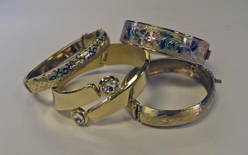 Group of Gold Bangle Bracelets: Consisting of two possibly gold filled bangles, one with a etched floral design, and one diamond etched design together Monet brushed gold and a Rhinestone gold bangle bracelet