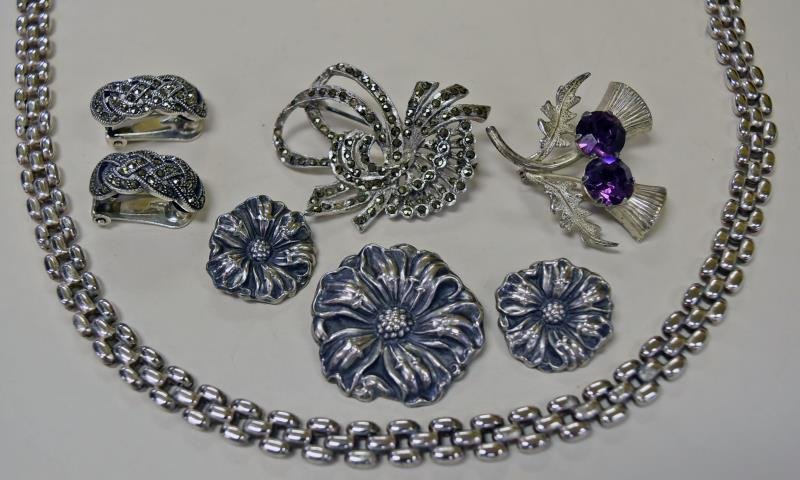 Group of Sterling Silver jewelry: Consists of marcasite pin and earrings, Sterling silver necklace, Sterling Silver pin with purple rhinestones and pin and earring set marked Sterling Silver front