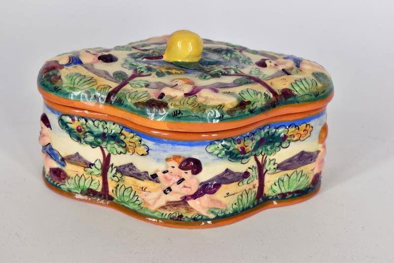 Vintage Italy Capodimonte Covered Jar Decorated with: Decorated with cherubs and children, several nicks on the rim.