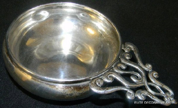 TIFFANY & CO STERLING SILVER PORRINGER: Has a scroll design pierced handle. Has a monogram to front. Tiffany makers mark to bottom. Marked with the number 12733A 7009. Dated May 3, 1909. B. Gills Impressed marked on bottom. Measures 1 3/4""
