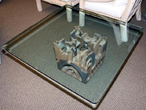 GEORGE GREENAMYER COFFEE TABLE WITH GLASS TOP: VLADIMIR KAGAN / GEORGE GREENAMYER Coffee table with plate glass top resting on an earthenware base with applied glaze. Base marked Greenamyer. Measures 16" H x 42" W x 42" L (40.5cm x 106.5cm x 106.5