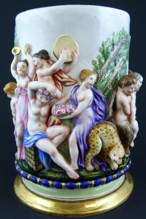 ANTIQUE CAPODIMONTE PORCELAIN CHERUBS STEIN: Has a 3-D scene depicting people drinking and dancing with cherubs and fauns. Has a figural goat handle. Gilted interior. Blue 5 point crown over N mark to bottom. 19th century. Measures 5 1/2" height