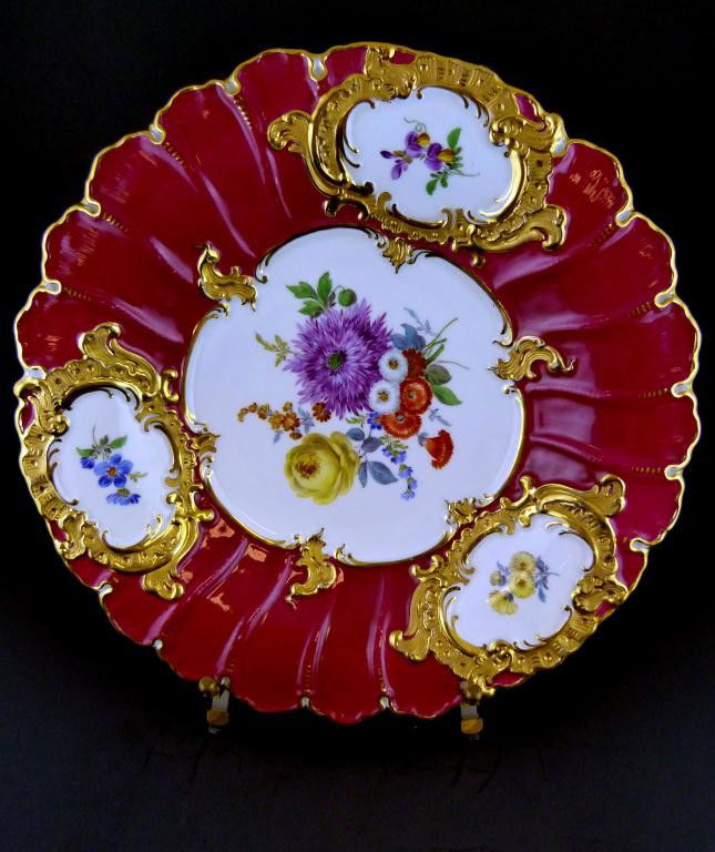 MEISSEN GERMANY HAND PAINTED FLORAL CHARGER: Has a hand painted floral design. Also has an incredible scrolled gilded design over a red background. Scalloped edges. Has blue cross swords mark on bottom. Impressed F152a and 14. Also marked 718 -