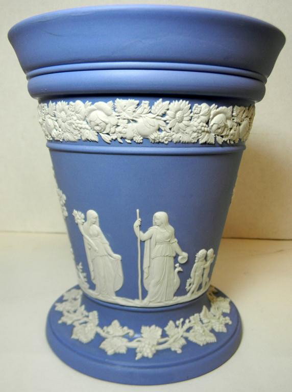 WEDGWOOD BLUE JASPERWARE VASE w FROG: Depicts woman, cherubs and trees. Has grapevine and floral border design. Wedgwood marks to bottom. Includes original flower frog. Measures 7" height x 6" diameter (18cm x 15.3cm).