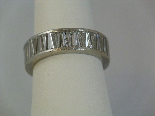PLATINUM & DIAMOND LADIES WEDDING BAND: Lovely platinum wedding band with approximately thirty-two .18ct diamond baguettes. Weighs 3.40dwt/5.4grams with stones. Ring size is 6 1/2.