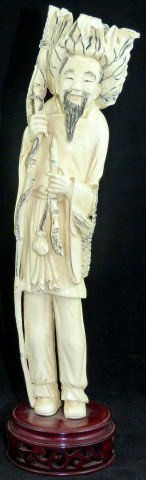 CHINESE IVORY FIGURE OF FISHERMAN WITH PIPE: Depicts a fisherman with a pipe in his left hand. In his right hand is a bamboo pole with a fish tied to a rope. Hanging from his left arm is a basket. Measures 12 3/8" height + 1 3/8" base (31.4cm x 