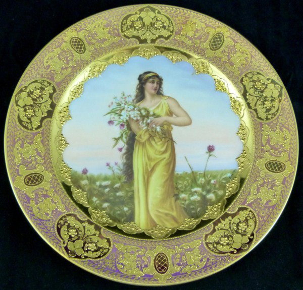ROYAL VIENNA PORCELAIN PORTRAIT PLATE WAGNER: Magnificent Royal Vienna portrait plate depicting a woman with flowers standing in a field of flowers. Titled "Flora" and numbered 78A. Has incredible gold gilded border. Blue Bee-Hive mark to bottom.