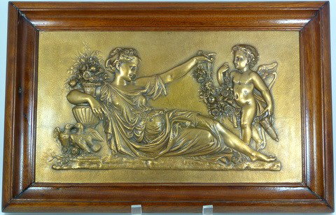 BRONZE METALLIC COMPRESSION CASTING COMPANY PLAQUE: Heavy bronze rectangular plaque depicting a reclining Venus with cherub. Each marked to back "CAST BY THE METALLIC COMPRESS. CASTING CO. No46 CONGRESS ST. BOSTON MASS.". Mounted in a wooden frame. Mad