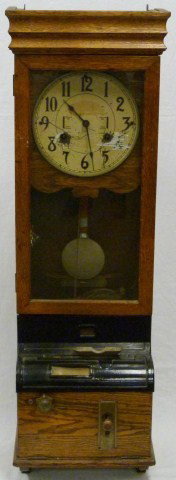 ANTIQUE WOODEN WALL PUNCH CARD TIME CLOCK: Hand carved wood time clock with glass casing. Punch card insert and brass levers to front. Early 20th century. Measures 47" height x 15" width x 10 1/2" depth (119.3cm x 38.1cm x 26.6cm).