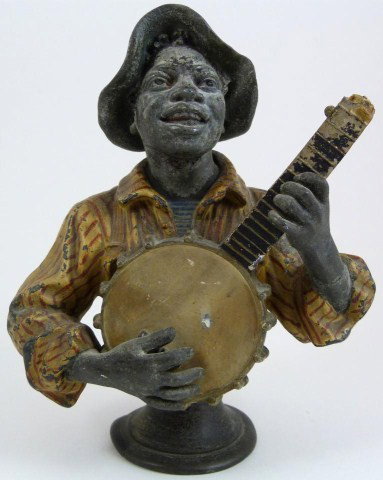 CAST IRON BLACK MAN PLAYING BANJO FIGURE: Depicts a black man playing the banjo. Circa 1920. Measures 7 1/2" height (19cm).