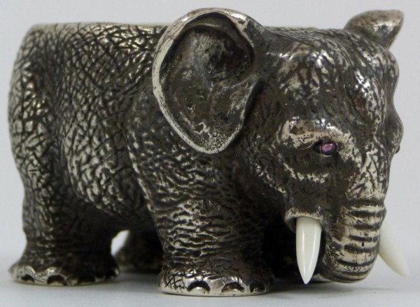 RUSSIAN SILVER STANDING ELEPHANT FIGURE: Russian silver standing elephant figure with open bowl back. Has pink cabochon stones set to eyes and ivory tusks. Town marks, 84 silver purity marks, and work master marks to bottom of foot. Measures