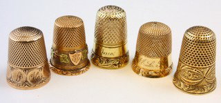 14k YELLOW GOLD THIMBLES - LOT OF 5: Lot of five 14kt yellow gold thimbles. Knurled to top and sides. All have engraved patterns to side. Each measures 3/4" to 7/8" (19mm to 22mm) height. Total weight 13.3dwt (20.8g).