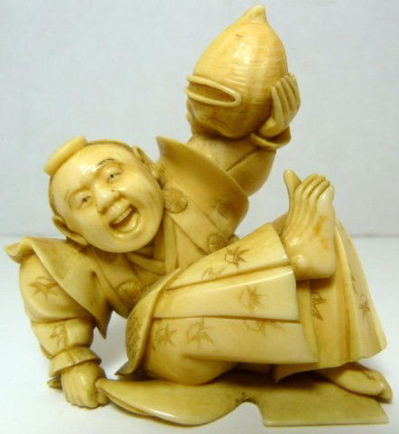 ORIENTAL IVORY FIGURE OF FALLEN FLAGMAN: Piece depicts a man who has fallen to the ground. He is holding a flag in his right hand and a shell horn in his left. The man is wearing a layered robe with etched flower and cross-hatch design. Sign