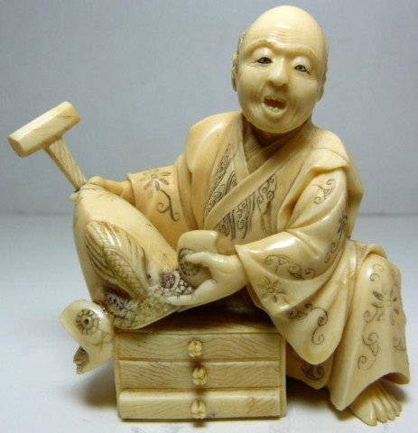 ORIENTAL IVORY FIGURE OF CRAFTSMAN: Piece depicts a man sitting and holding a decorative helmet that he made. He is holding a hammer in his right hand. Under the hat is his tool box. The man is wearing a layered robe with etched flower 