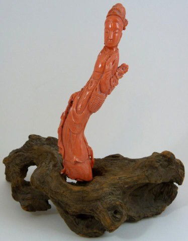 CHINESE CARVED RED CORAL MAIDEN FIGURE: Depicts maiden with flowers and basket with necklace and headdress. 19th/20th century. Set on freeform wooden base. Measures 7 1/2" + 2 1/2" base (19cm + 6.3cm). Coral weighs 222.9g.