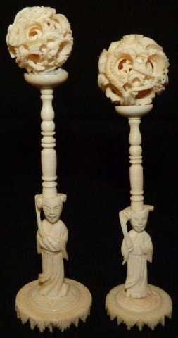 PAIR OF CHINESE IVORY CONCENTRIC BALLS w STANDS: Hand carved Chinese Ivory Dragon 5 layer concentric balls. Stands are decorated with carved figures of robed men holding staffs. 19th/20th century. Each measures approximately 5 1/2" height (13.9cm).