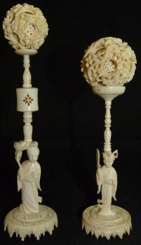 2 CHINESE IVORY CONCENTRIC BALLS w STANDS: One concentric ball has a dragon design with approximately 10 layers, 2" dia (5cm). The other has a floral design with approximately 8 layers, 1 5/8" dia (4.3cm). Stands have carved design depicting m