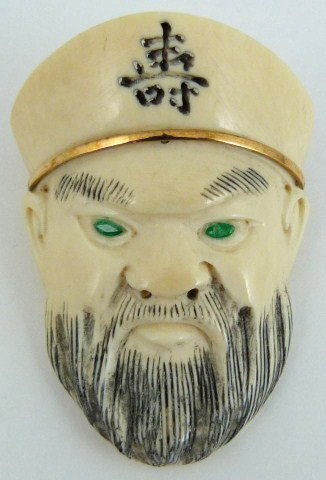 14kt YG CARVED IVORY KING PENDANT w EMERALD EYES: Carved ivory pendant depicts face of Chinese bearded mean. 14kt yellow gold bail + hat band. Creamy color. Eyes are marquise shaped faceted emeralds, approx .10ctw. Two holes drilled through top of ha