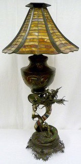 IMPRESSIVE BRONZE & ENAMEL CHAMPLEVE DRAGON LAMP: Large figural bronze and enamel lamp depicting a dragon holding up an urn. Highly decorated throughout. Has slag glass shade. 19th century. Measures 48" height (121.9cm).