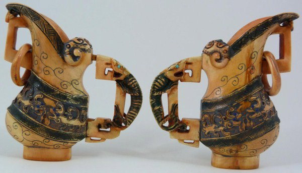 PAIR OF CHINESE IVORY POLYCHROMED IVORY PITCHERS: Pair of antique Chinese Ivory carved pitchers. Polychromed throughout. Figural dragon handles. Has relief carved rings to the front of spout. Relief carved dragon design to sides. Signed to bottom. 19