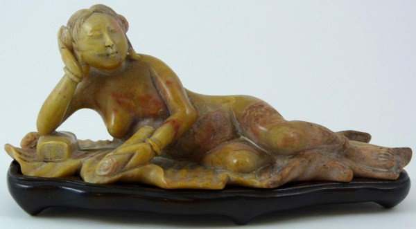 CHINESE SOAPSTONE CARVED NUDE FEMALE FIGURE: Chinese carved soapstone figure depicting a reclining nude female with scroll. Has fitted wooden stand. 19th/20th century. Measures 2 1/2" height x 6 1/4" length + 1/2" base height (6.3cm + 1.2cm).