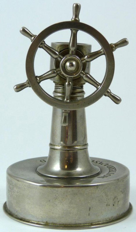 OLD SILVER ON BRASS SHIPS WHEEL CIGAR CUTTER: This item is a brass ship's wheel cigar cutter. It's marked on top of the base "ROTTERDAMSCHE LLOYD" (Rotterdam Lloyd). This is a Dutch shipping company. This was a souvenir item sold aboard their pas