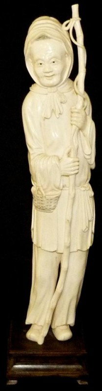 ANTIQUE CHINESE HAND CARVED IVORY FISHERMAN FIGURE: Chinese hand carved ivory figure depicting a fisherman with bamboo fishing pole and basket on right forearm. Has hidden compartment to top of head (see photos). Signed to back of right thigh. Measures