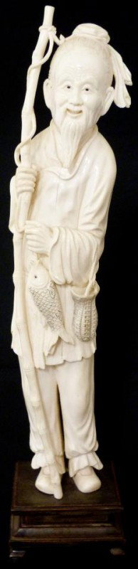 ANTIQUE CHINESE HAND CARVED IVORY FISHERMAN FIGURE: Chinese hand carved Ivory figure depicting a fisherman with bamboo fishing pole in left hand and basket & fish to left hand. Signed to back of right thigh. Measures 14 1/4" height + 1 3/4" base (36.1c