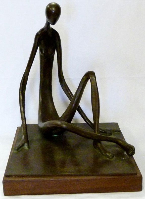 RAMIZ BARQUET BRONZE FIGURE ON WOODEN BASE: Ramiz Barquet (Mexican). Abstract bronze figure depicting a man sitting. Signed to back and dated 1975. Measures 17 1/2" height + 2" base height (44.4cm x 5.1cm).