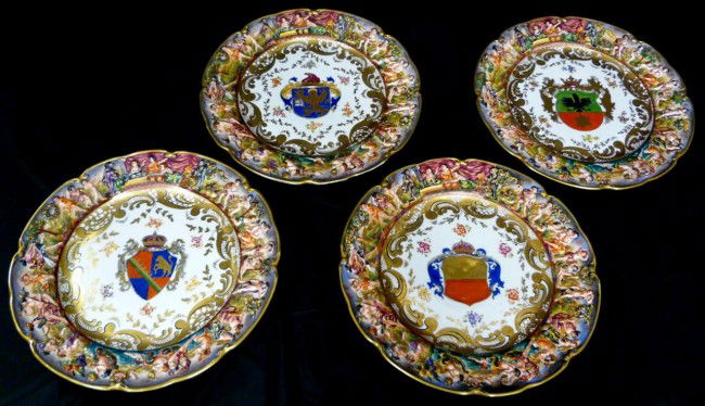 4 ANTIQUE CAPODIMONTE PORCELAIN CHERUB PLATES: Four antique Capodimonte Italian porcelain dinner plates. Each has a raised figural design to rim. To the center of each plate is a different crest. Blue crowned N mark to bottom used 1782-1834. Each